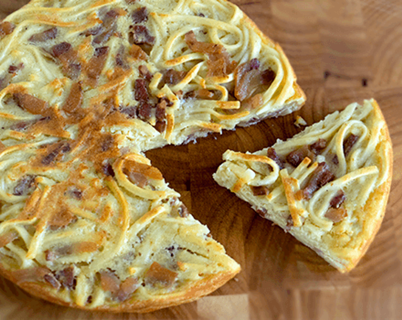 step 14 Once it is ready, flip it again so the golden brown side is on top. Remove the spaghetti frittata carbonara from the pan and leave it on a large, round, flat plate to serve. Cut into pizza-shaped slices for a larger serving or into squares for an antipasto dish.