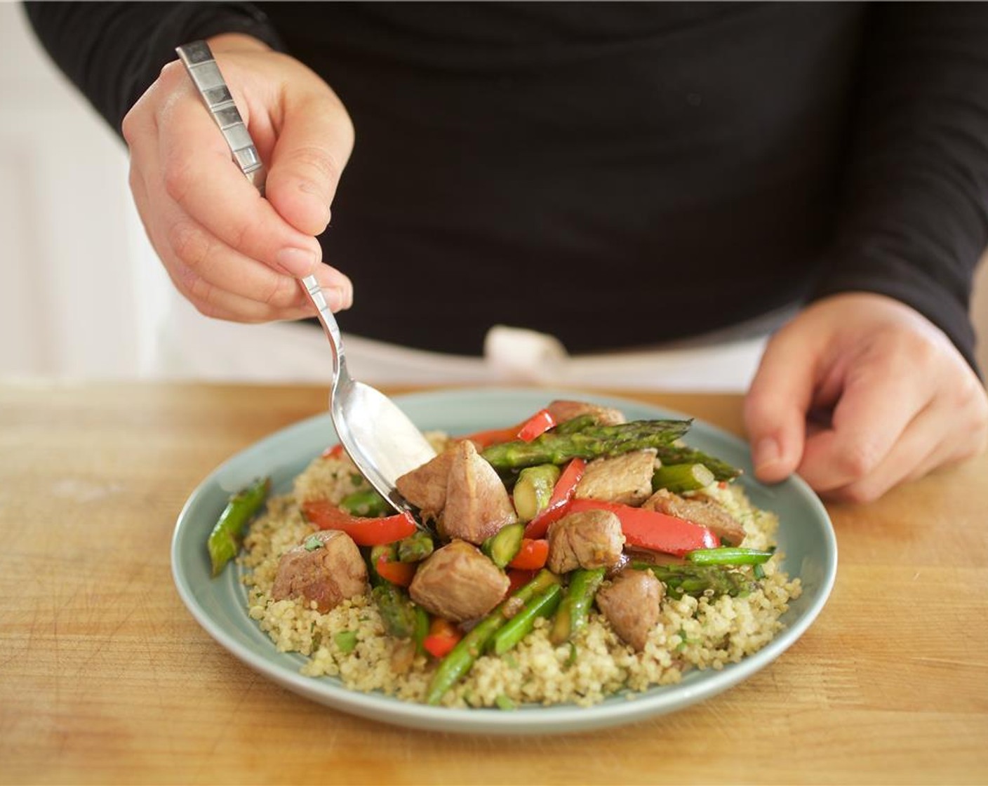 step 14 Fluff the quinoa with a fork and fold in cilantro. In the center of two plates, place the quinoa. Top with the pork and vegetables stir fry.