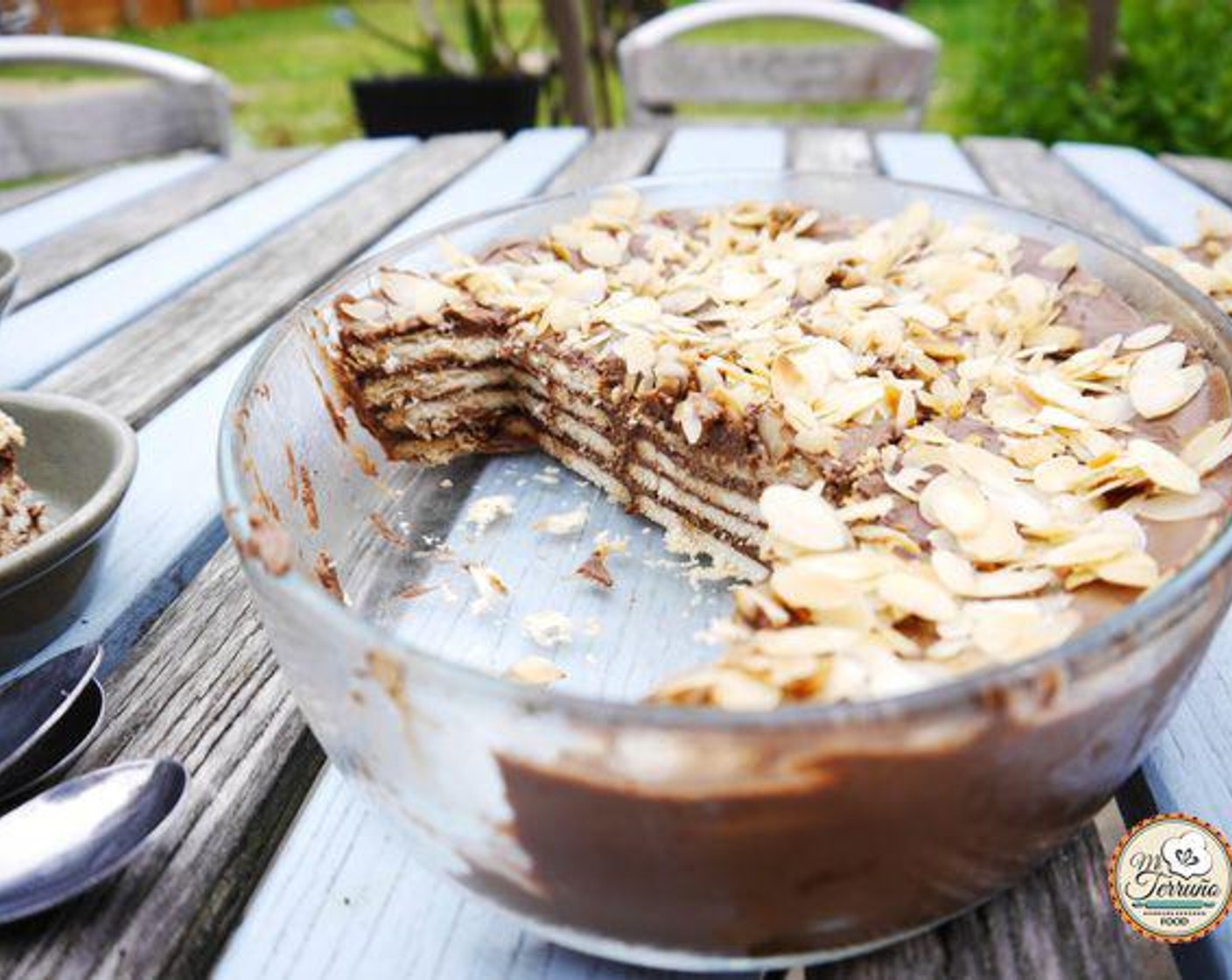 step 5 Finish the cake with a layer of chocolate and sprinkle some roasted almond flakes, or crunched pistachios or even grated chocolate. Cover the tray with cling film and place in the fridge over night. Serve and enjoy!