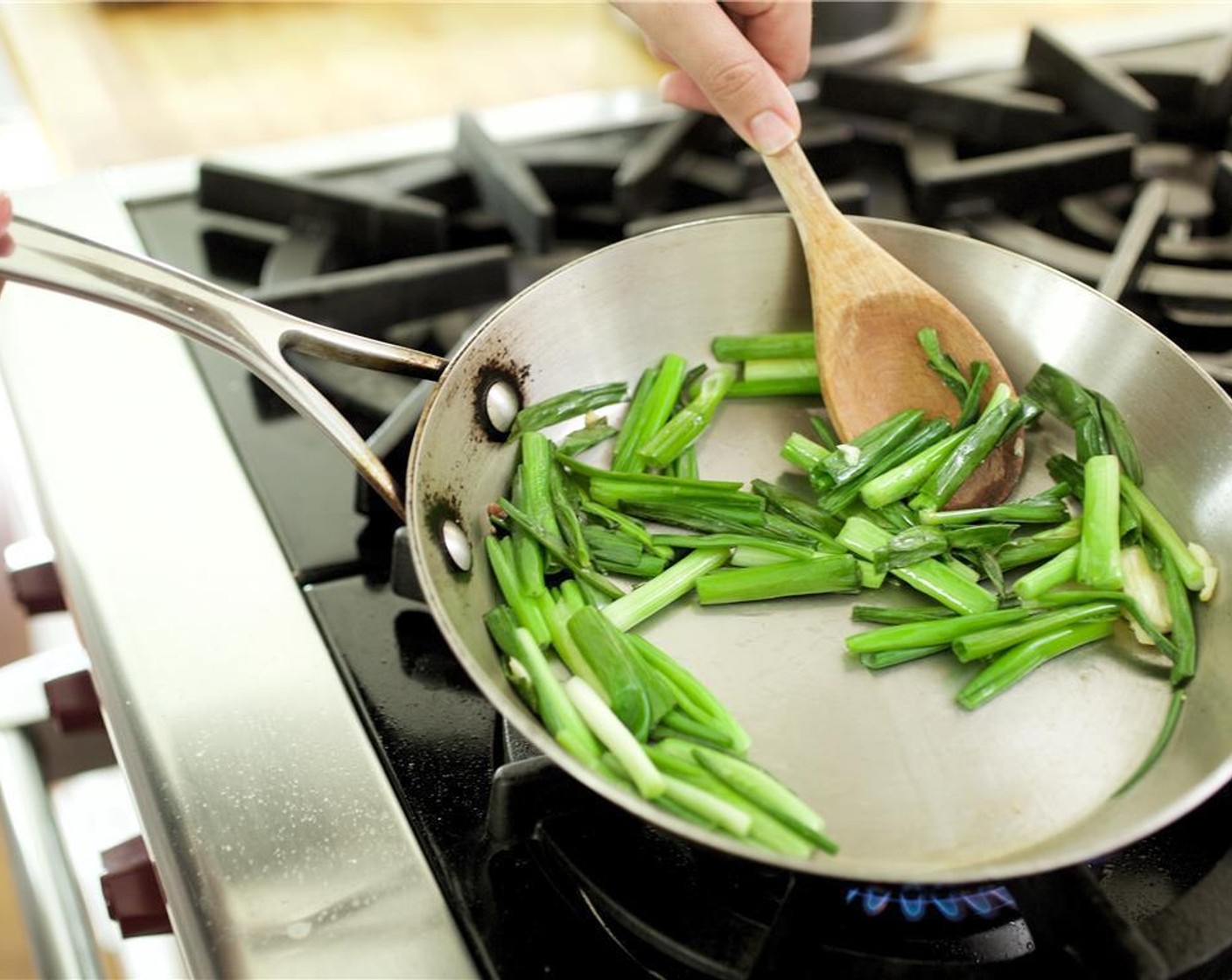 step 6 In a large saute pan over medium high heat, add one tablespoon of olive oil. Saute garlic and green onions for two minutes. Remove green onions from pan and set aside.