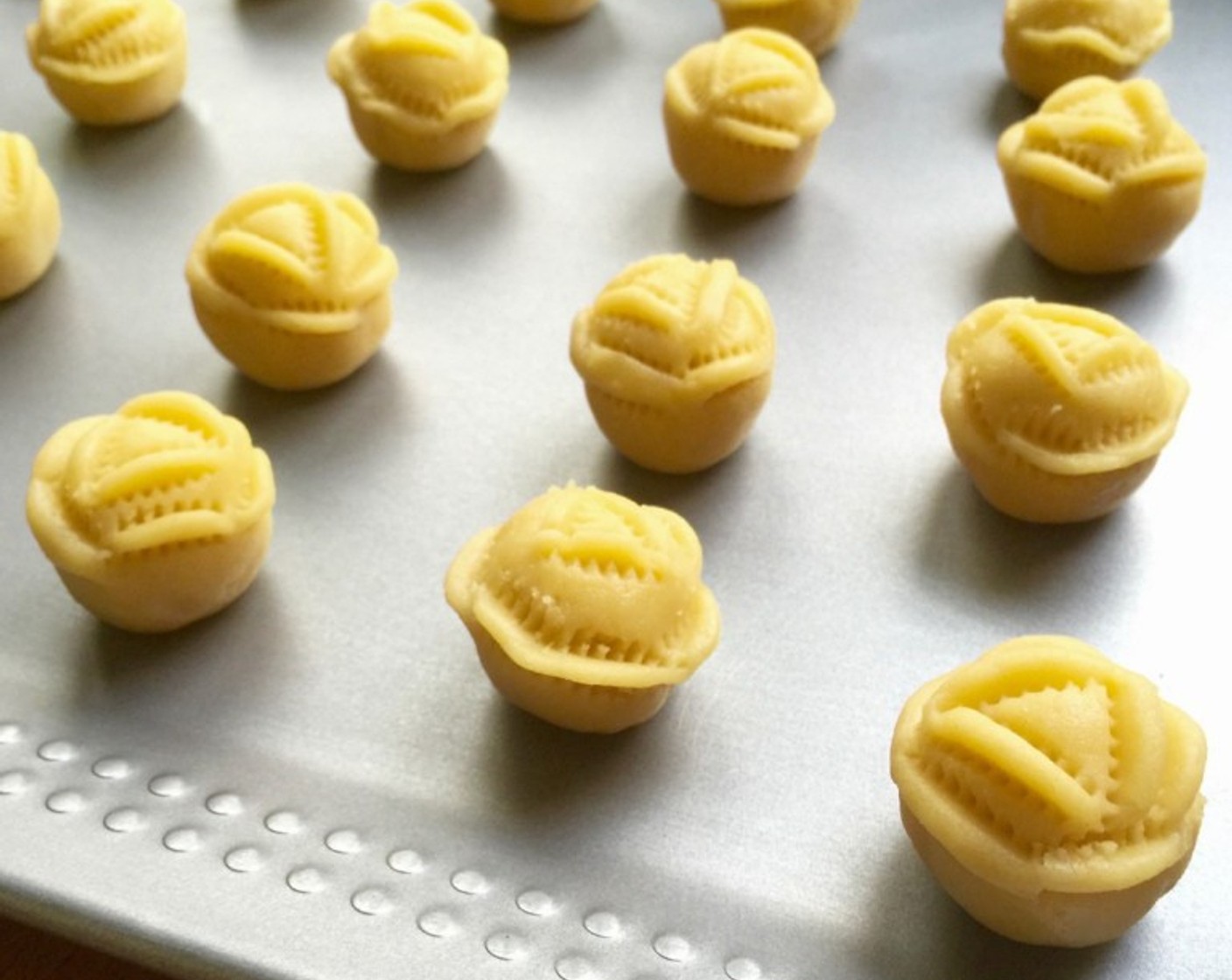 step 17 Continue to roll and crimp for the rest of the pineapple rolled dough balls. Then arrange the rose shape pineapple tarts on a baking tray.