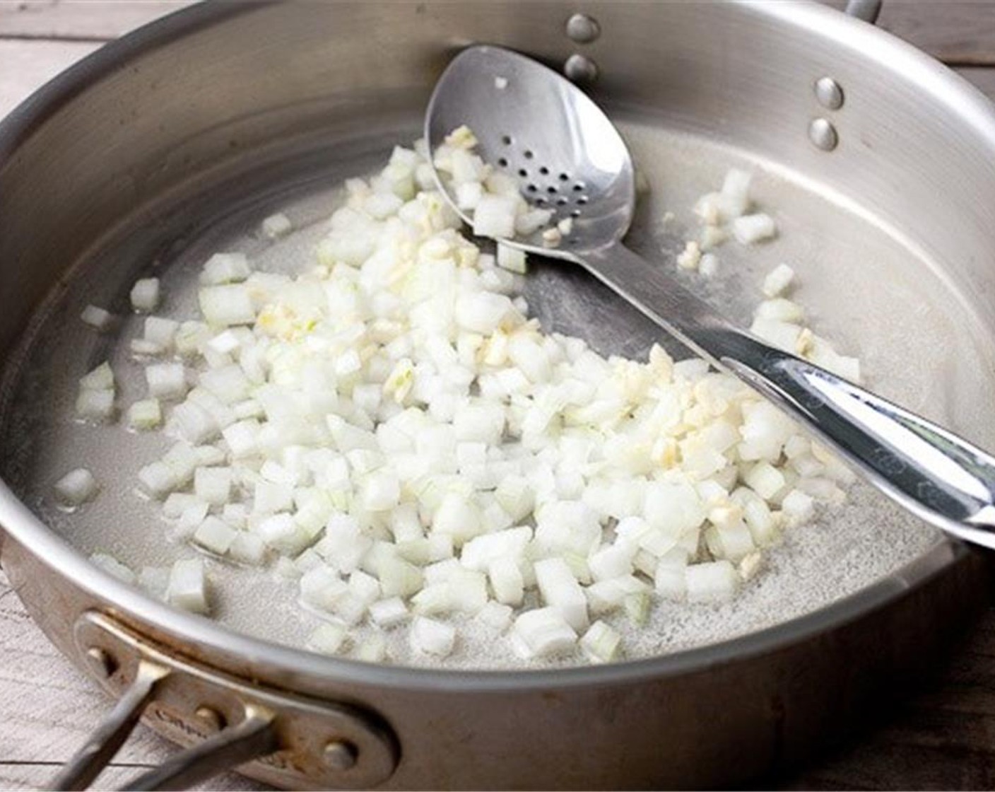 step 3 To start the risotto, cook White Onion (1/2) and Garlic (4 cloves) in Butter (2 Tbsp) over medium heat until soft.