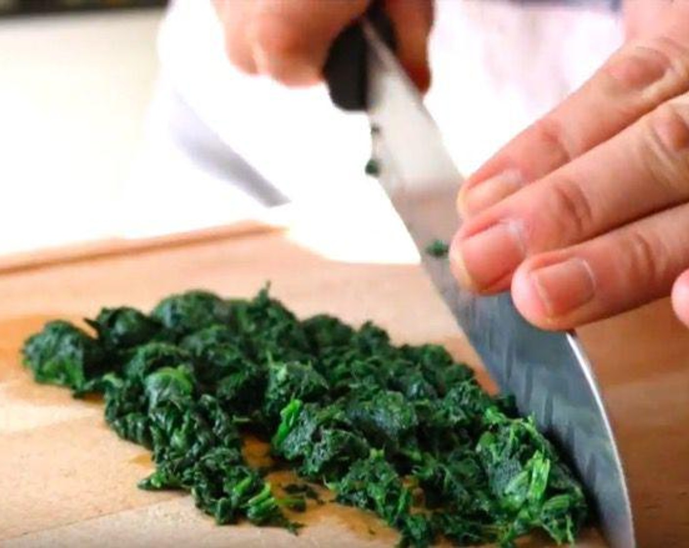 step 4 Remove the lid and mix the spinach, then transfer the spinach to a sieve with a bowl underneath. Using a wooden spoon, push down on the spinach to remove all the excess liquid. Once done, roughly chop the spinach and set aside.