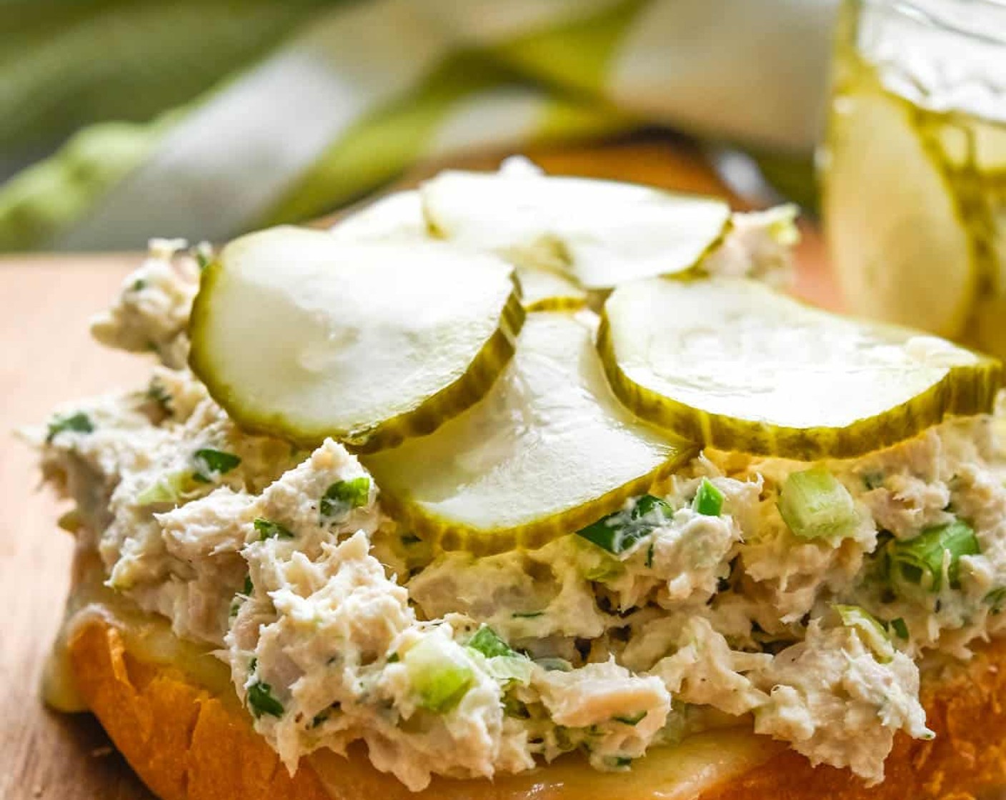 step 6 Remove the buns from the oven and top each slice of melted cheese with a mound of tuna fish, Pickled Cucumbers (to taste), and a slice of Tomato (1).