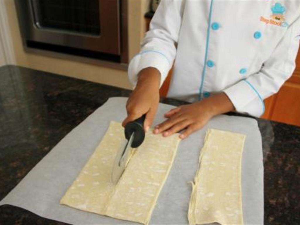 Step 3 of Sausage Bites With Maple Lemon Sauce Recipe: Cut along the puff pastry sheets fold lines to create three strips.