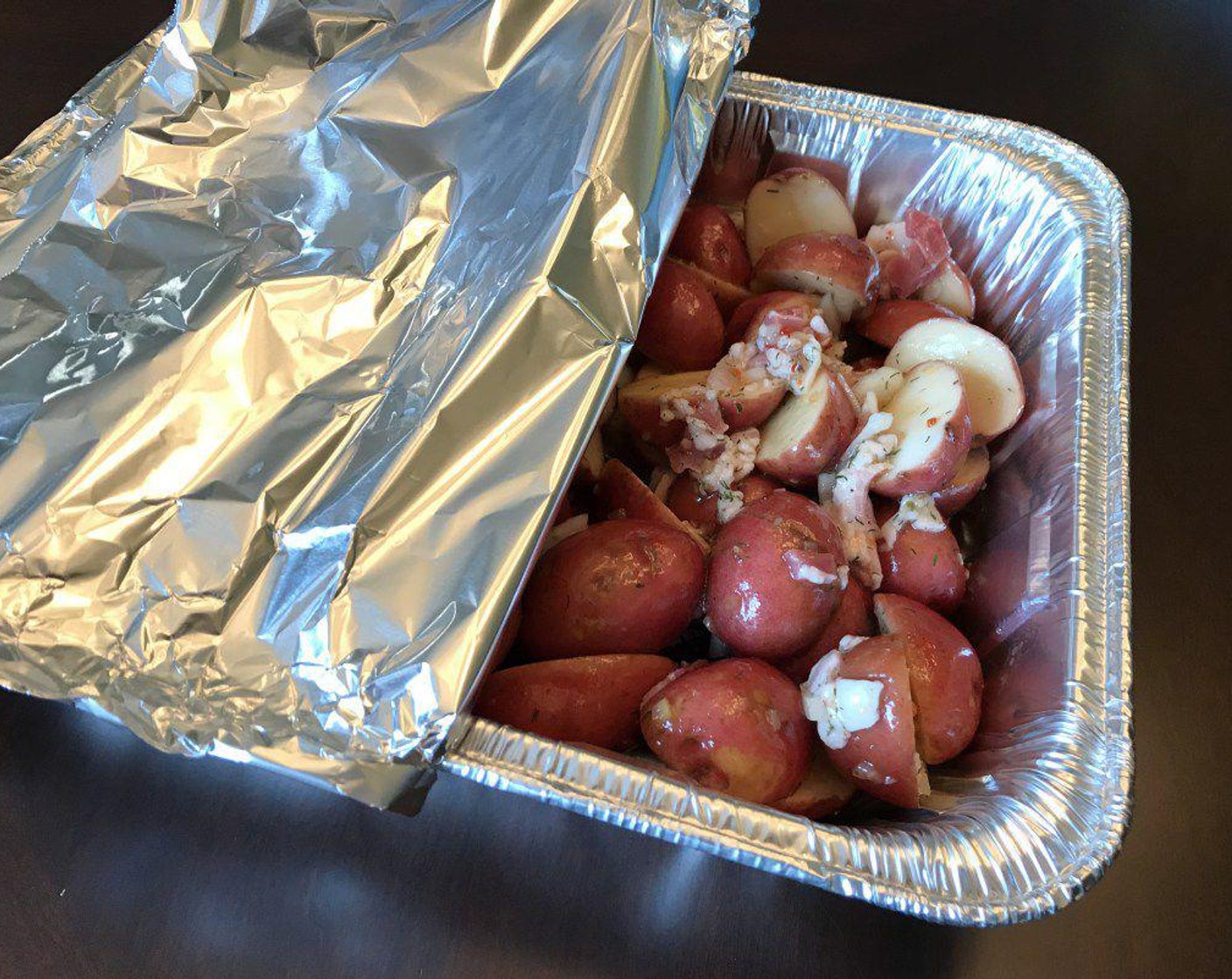 step 7 Pour potatoes into a 9x11 foil roasting pan (or equivalent size) and cover with aluminum foil.