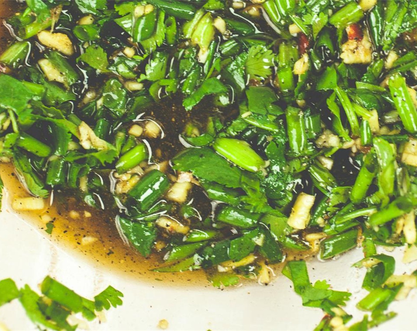 step 2 In a medium bowl, combine sliced green onion, cilantro, Soy Sauce (4 Tbsp), Sesame Oil (3 Tbsp), Rice Vinegar (3 Tbsp), Agave Syrup (3 Tbsp) half of the ginger, garlic, Salt (1/2 tsp), Ground Black Pepper (1/4 tsp), and Fresh Ground Chili Paste (1/4 tsp). Set this sauce aside for later. Bring a large pot of water to a boil for the noodles.