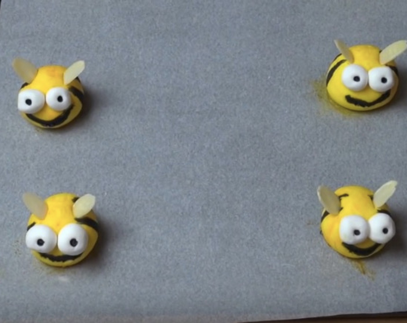 step 10 On a tray lined with non-stick baking paper, make the fondant bees by rolling White Icing Fondant (1 pckg) into small balls. Paint with Black Food Coloring (to taste) and Yellow Food Coloring (to taste). Use Sliced Almonds (to taste) for wings. Allow them to dry and firm up for 3 hours.