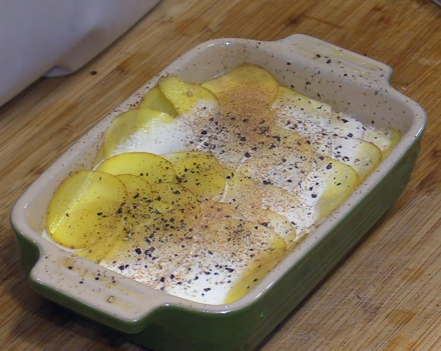 step 4 Layer on the thinly sliced potatoes. Keep repeating with cream, potatoes, and spices until the pan is filled.