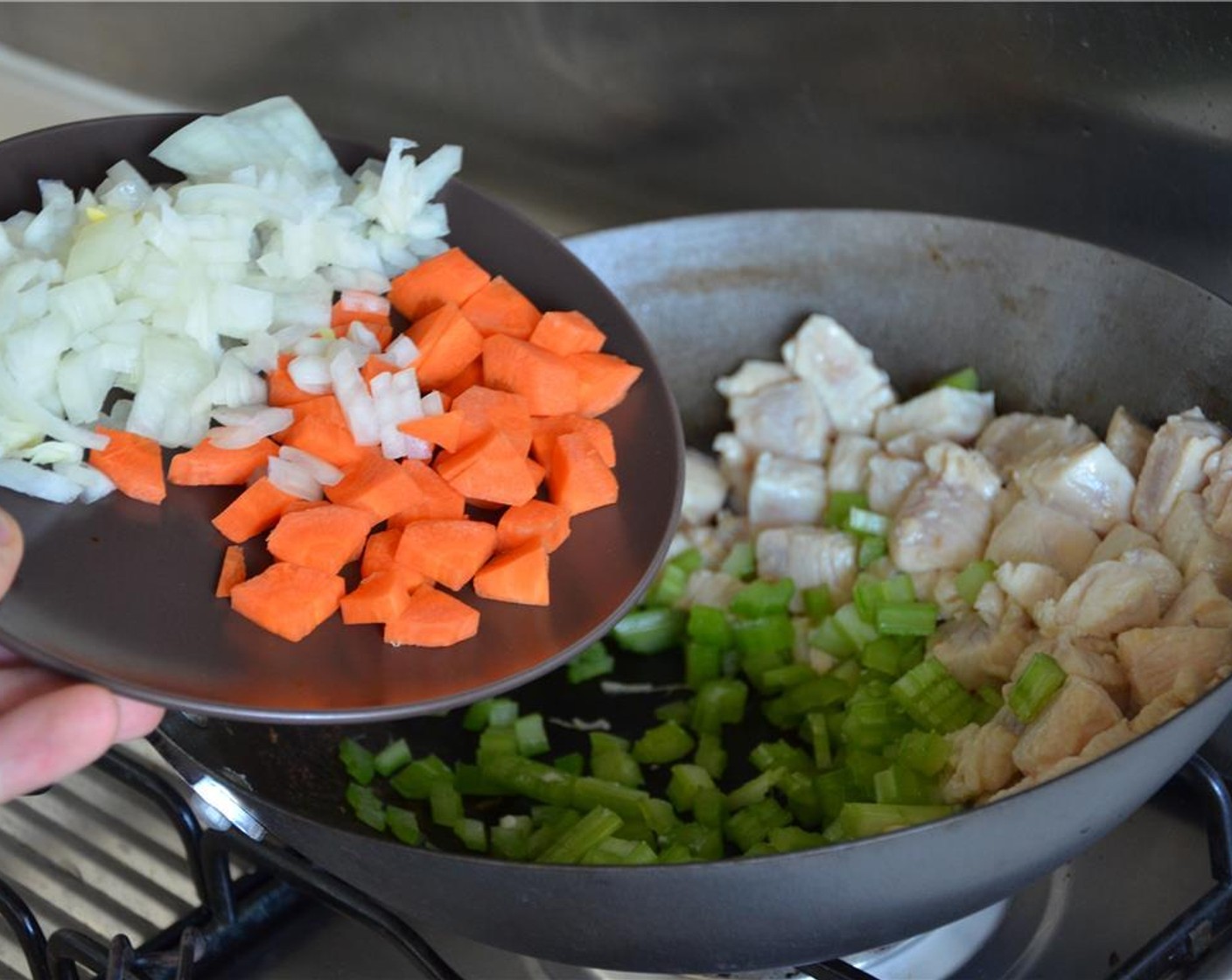 step 7 Add the carrot, celery, and onion. Stir fry for a minute.