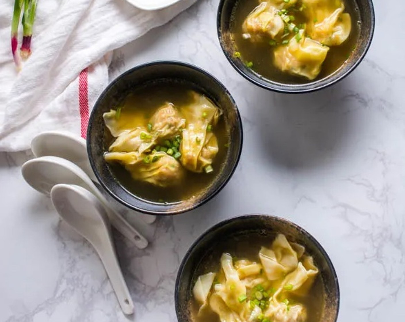 step 8 Transfer the soup into individual serving bowls. Place 3–4 wontons into each bowl.