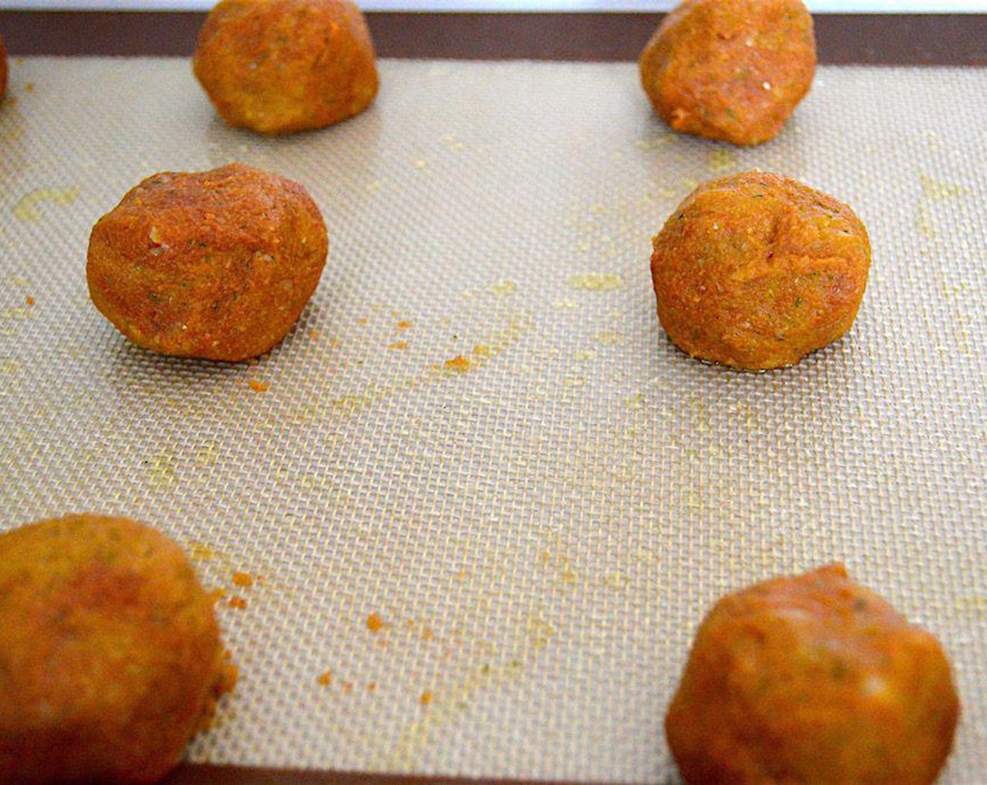 step 4 Lightly grease the lined tray with Olive Oil (as needed). Scoop out 2 tablespoon portions of the mixture and roll those portions into balls. Line the balls up on the prepared baking sheet and gently flatten each of them into small patties.