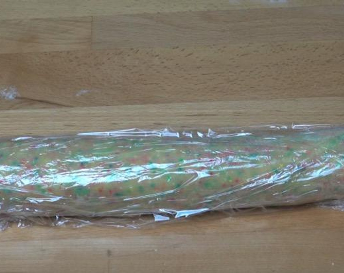 step 4 Transfer the dough to a lightly floured surface. Shape it into a 30-centimeter log and wrap the log in plastic wrap. Place in the fridge for 1-2 hours to firm up.