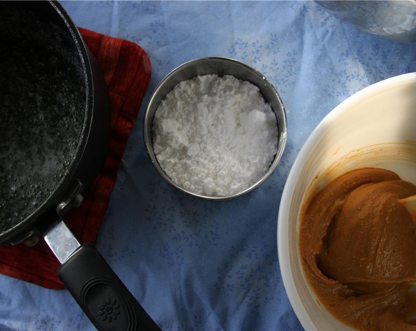 step 6 Remove from heat and add Peanut Butter (1/2 cup) to the pan and stir. Add Powdered Confectioners Sugar (1/2 cup) and Milk (2 Tbsp) or water. Stir until smooth.