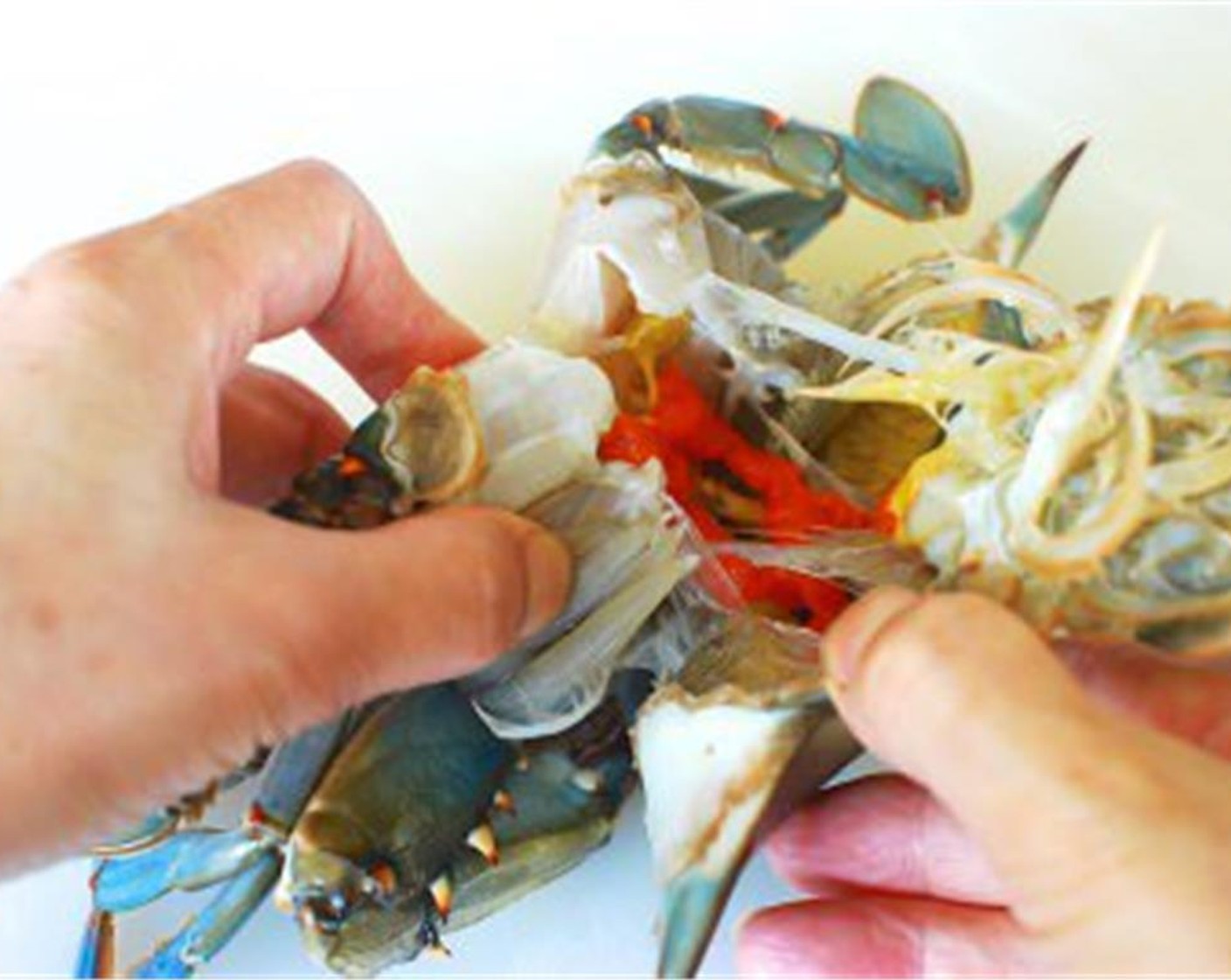 step 3 Plunge the frozen crabs in cold water to thaw. Separate the top shell and remove the gills. Clean the shell part of the crab thoroughly, with a kitchen brush or a toothbrush, under running water.