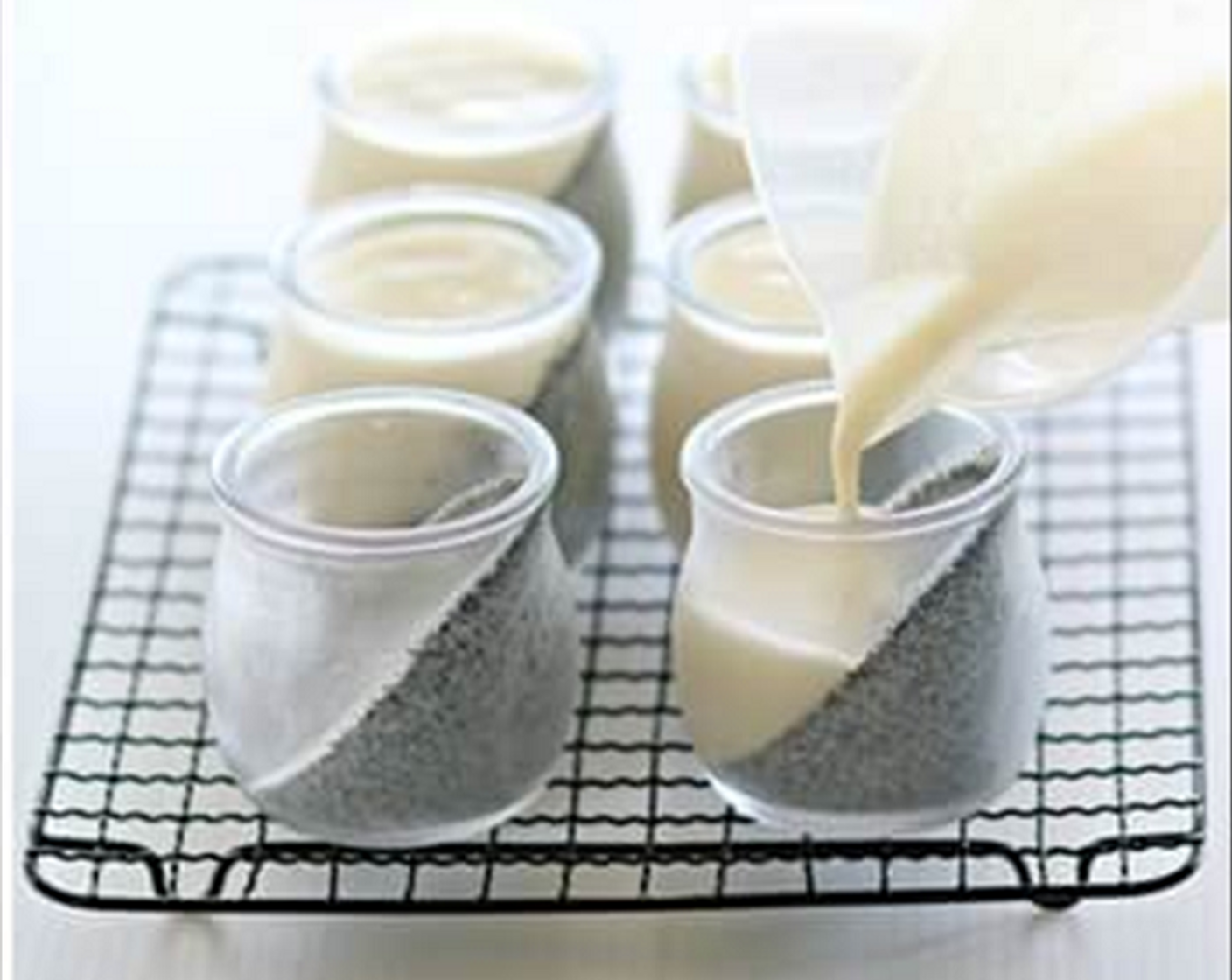 step 7 Remove the glasses of set black sesame pudding from muffin pan and stand them up right. Gently pour soya milk liquid onto set black sesame pudding.