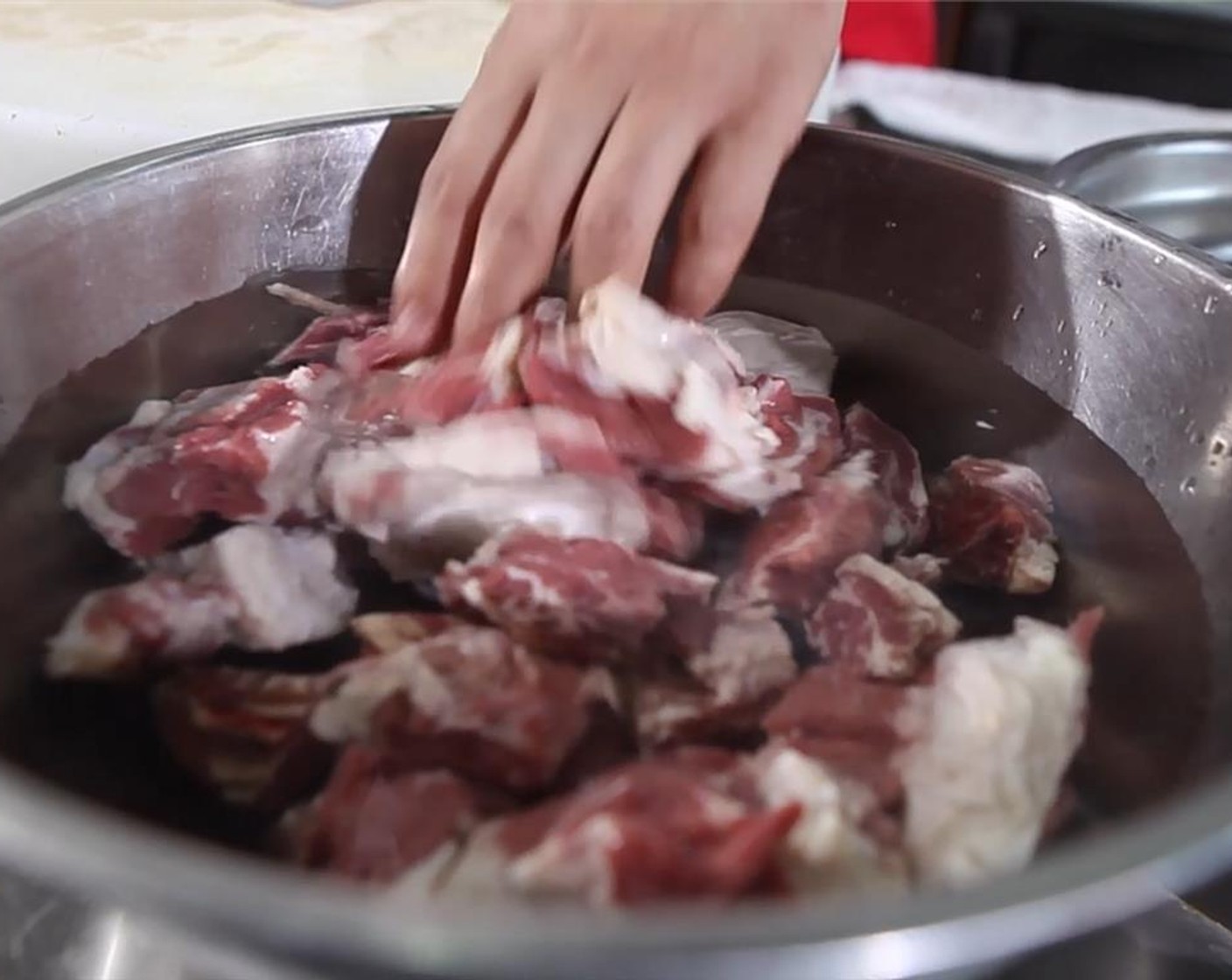 step 4 Place the cubed brisket into a large bowl. Wash away the blood with cold water. Rinse a couple times before draining the meat.