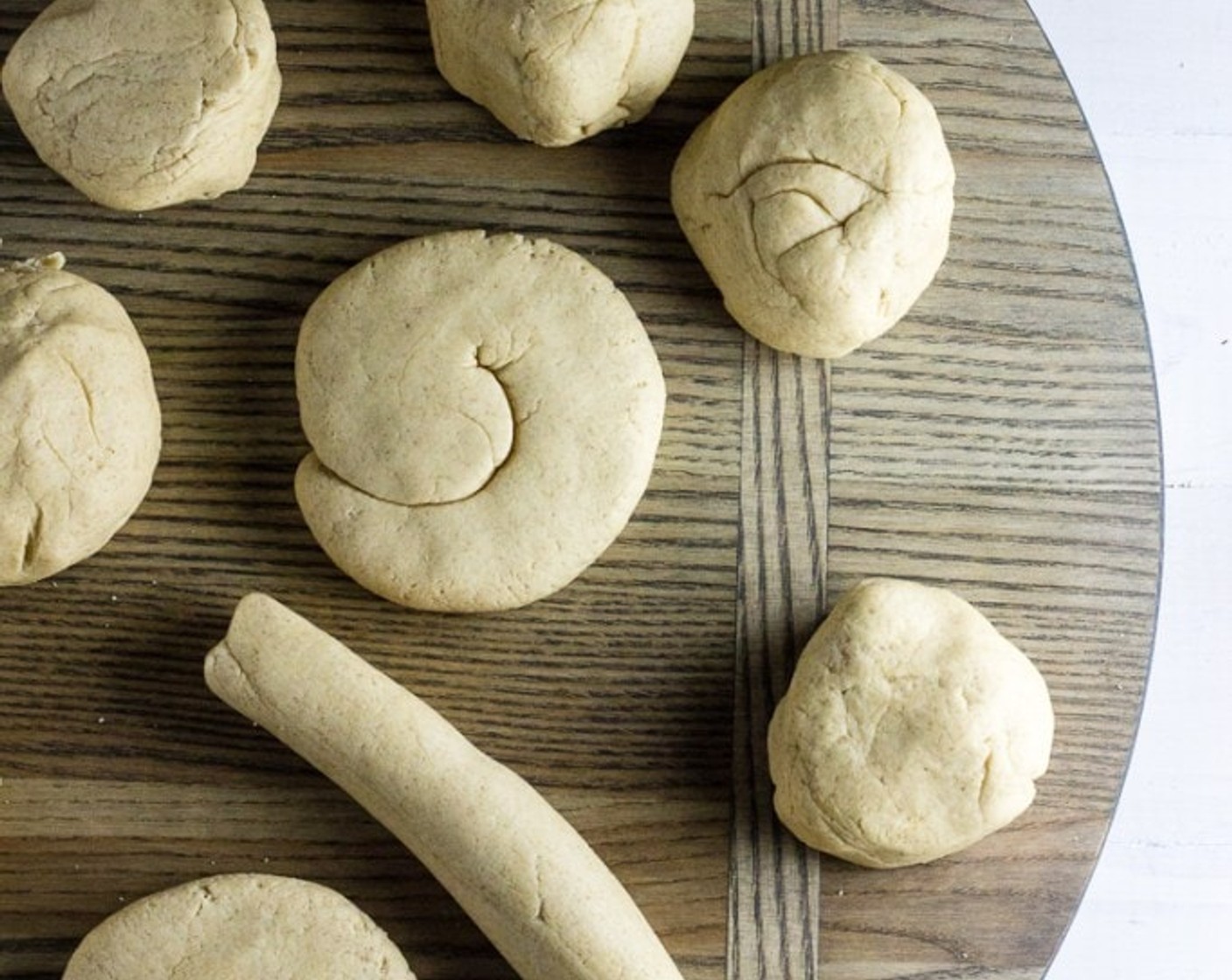 step 7 Divide dough evenly into 12 portions. Roll each portion into a cylinder about 7 inches long. Shape each cylinder into a gentle spiral and press evenly until about 4 inches in diameter.