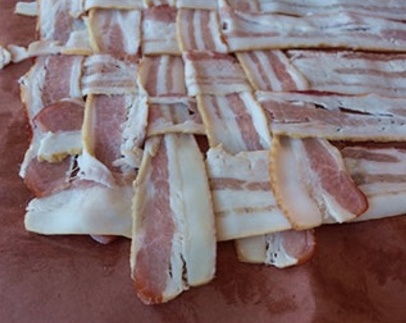 step 7 Lay out a sheet of wax or butcher paper on the work surface and use Bacon (2 lb) to build a 9x9 strip bacon weave.
