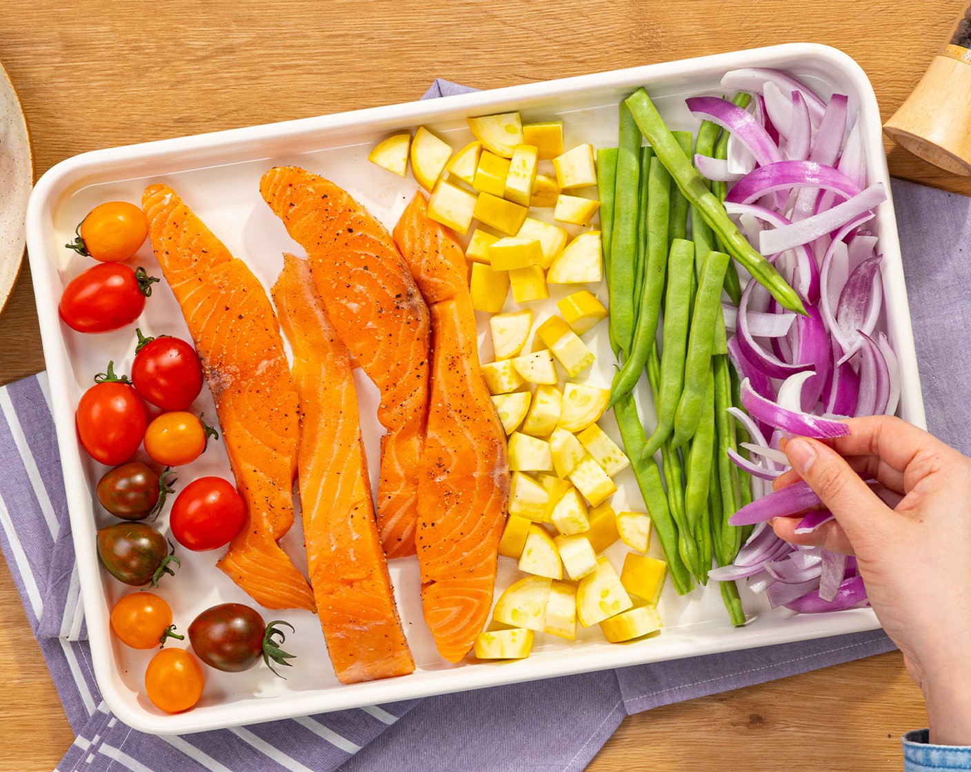 step 5 On the baking tray, lay Rainbow Grape Tomato (1 cup), salmon, yellow squash, Green Beans (1 1/2 cups), and red onion.