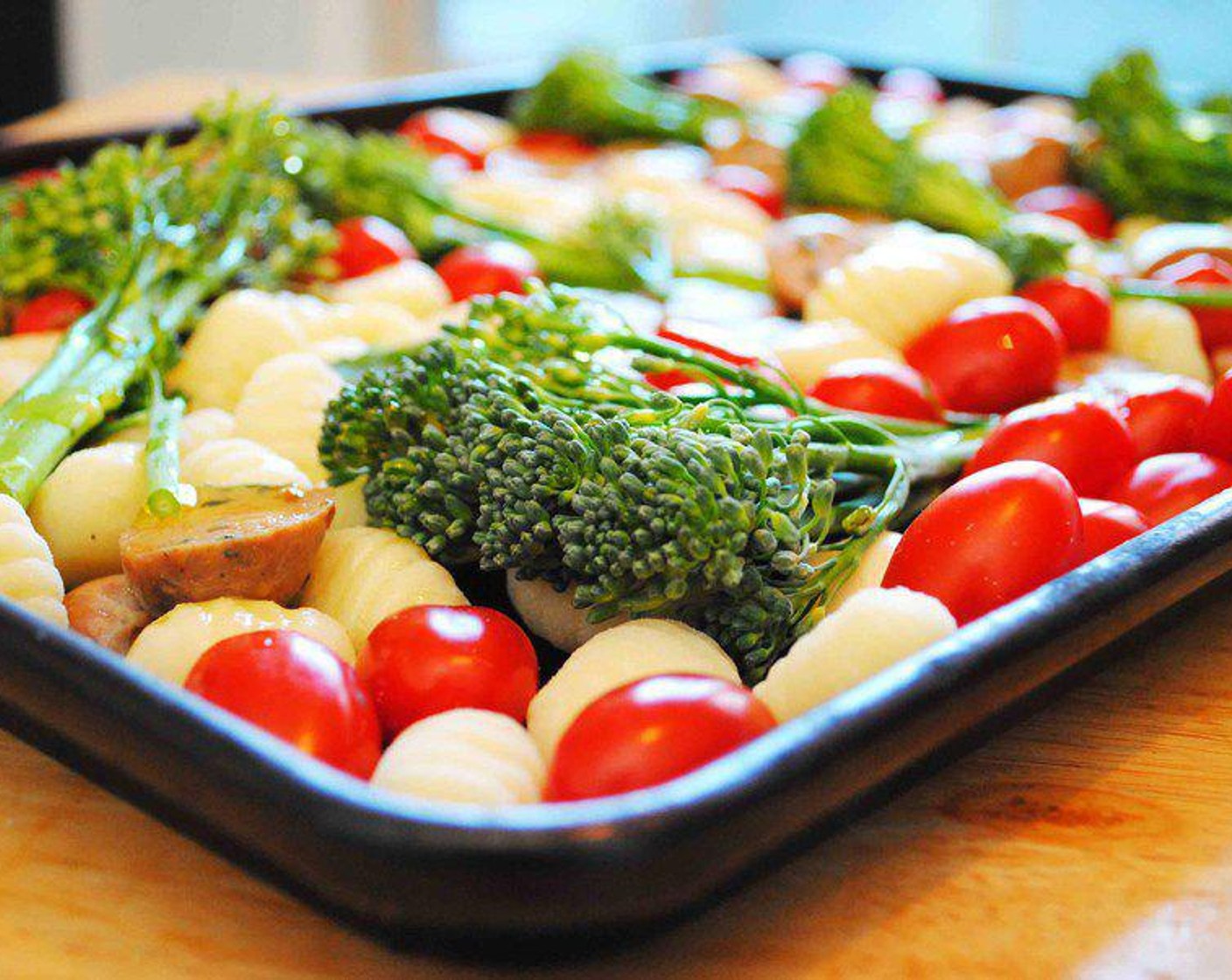 step 2 On a large sheet pan place the Gnocchi (1 lb), Cherry Tomatoes (2 cups), Italian-Style Chicken Sausages (12 oz), and Garlic (3 cloves). Toss them together to mix them evenly.