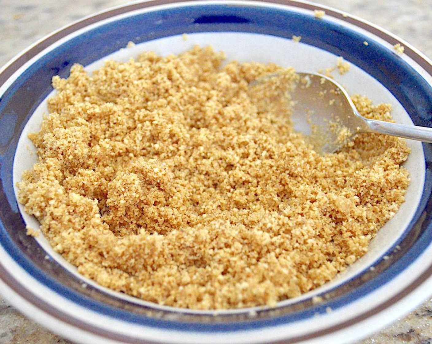 step 4 When the hour is up, it's time to assemble. First, quickly stir the Graham Cracker Crumbs (3/4 cup), Dark Brown Sugar (1 tsp) and melted Butter (2 Tbsp) together to make the crust. Then I love using glass mugs for this recipe so that it's like a butterbeer drink. Whatever size you decide to use, evenly distribute the crust mixture in the bottom of each mug.