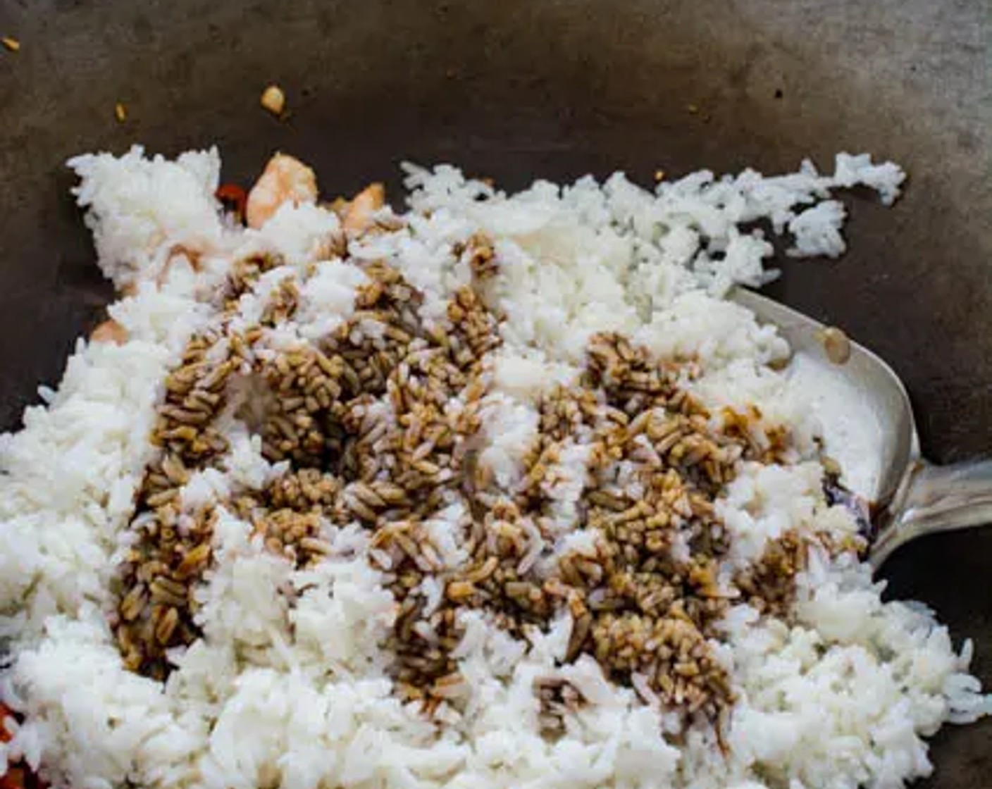 step 3 Pour the cooked White Rice (2 cups) into the wok, followed by Sweet Soy Sauce (3 Tbsp) and Light Soy Sauce (1 Tbsp). Stir well to distribute the sauce evenly in the rice.