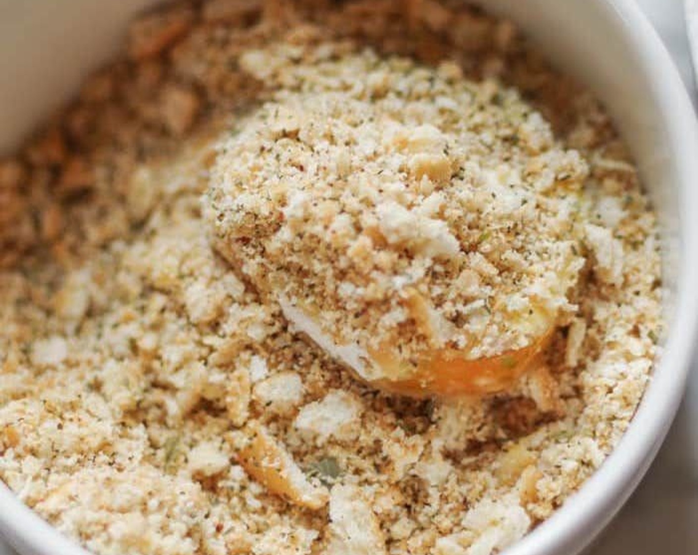 step 4 Pat the tomato slices dry. Working with one slice at a time, dredge it through the flour. Shake off any excess flour. Dip it into the beaten egg. Then submerge the slice in the crumb mixture. Lay it on a clean paper towel. Repeat with the remaining slices.