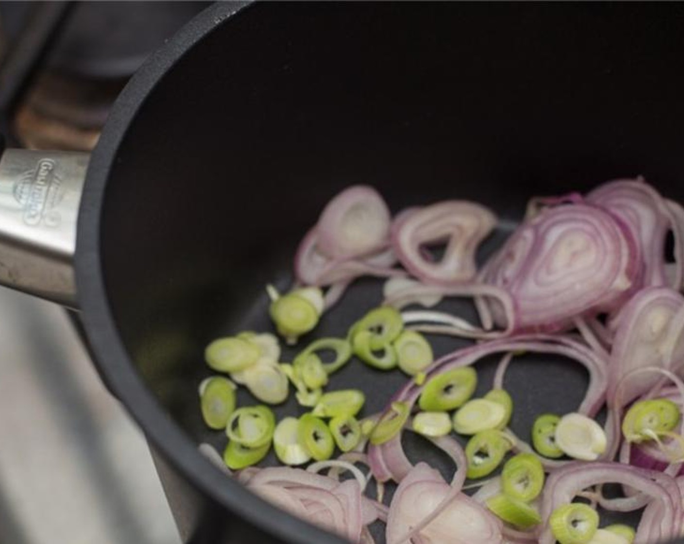 step 4 In a medium saucepan with a lid add Olive Oil (1 tsp), shallot, and spring onion whites. Place pan over medium heat, and cook, stirring intermittently, until onions turn translucent, 4-5 minutes.