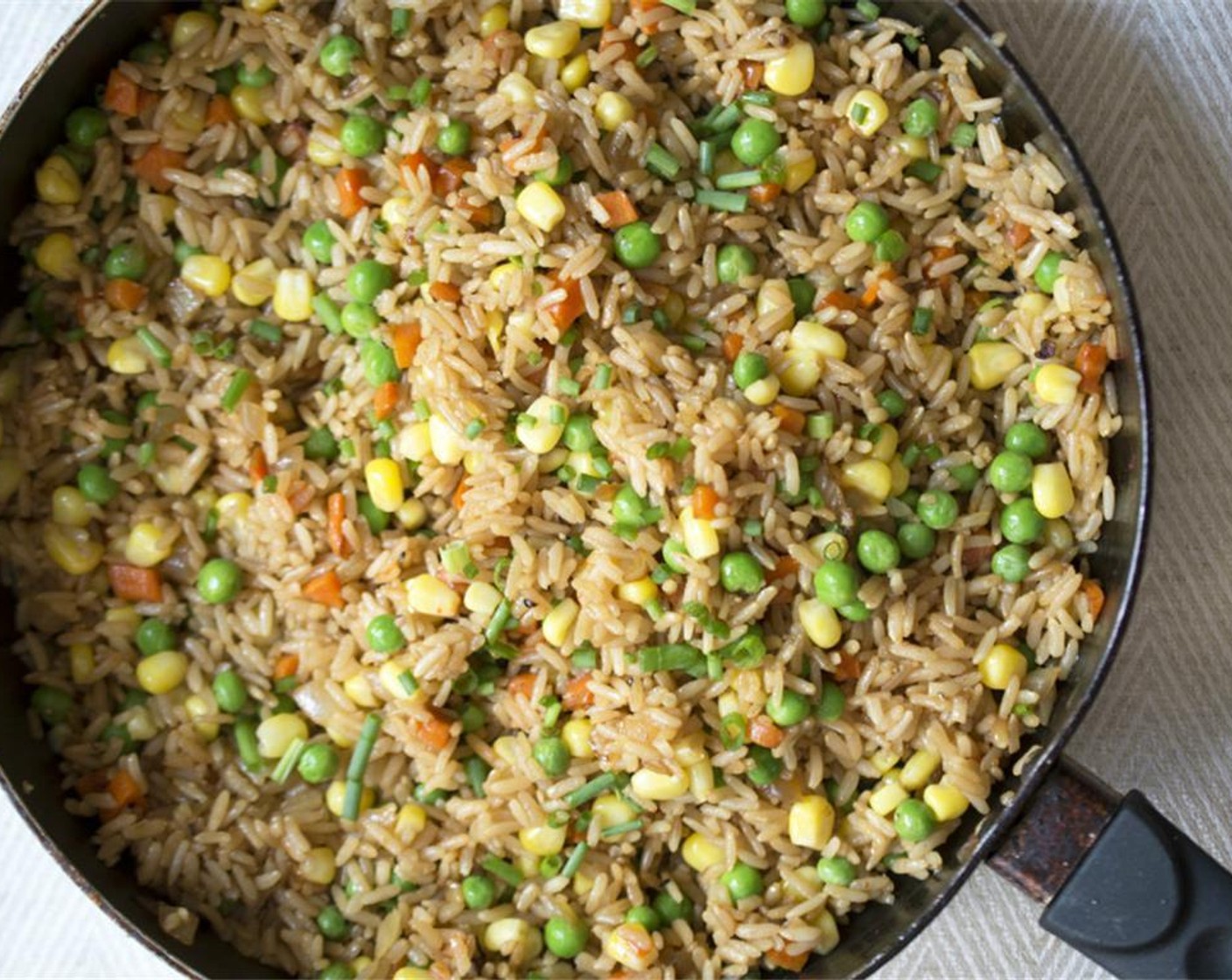 step 3 Add cooked rice into the pan with the carrot/onion mixture. Add the Frozen Green Peas (3/4 cup), Frozen Corn Kernels (3/4 cup), Sriracha (1/2 Tbsp), Fish Sauce (1/2 tsp), and Soy Sauce (2 Tbsp). Toss to combine. Keep the heat on low to keep warm.