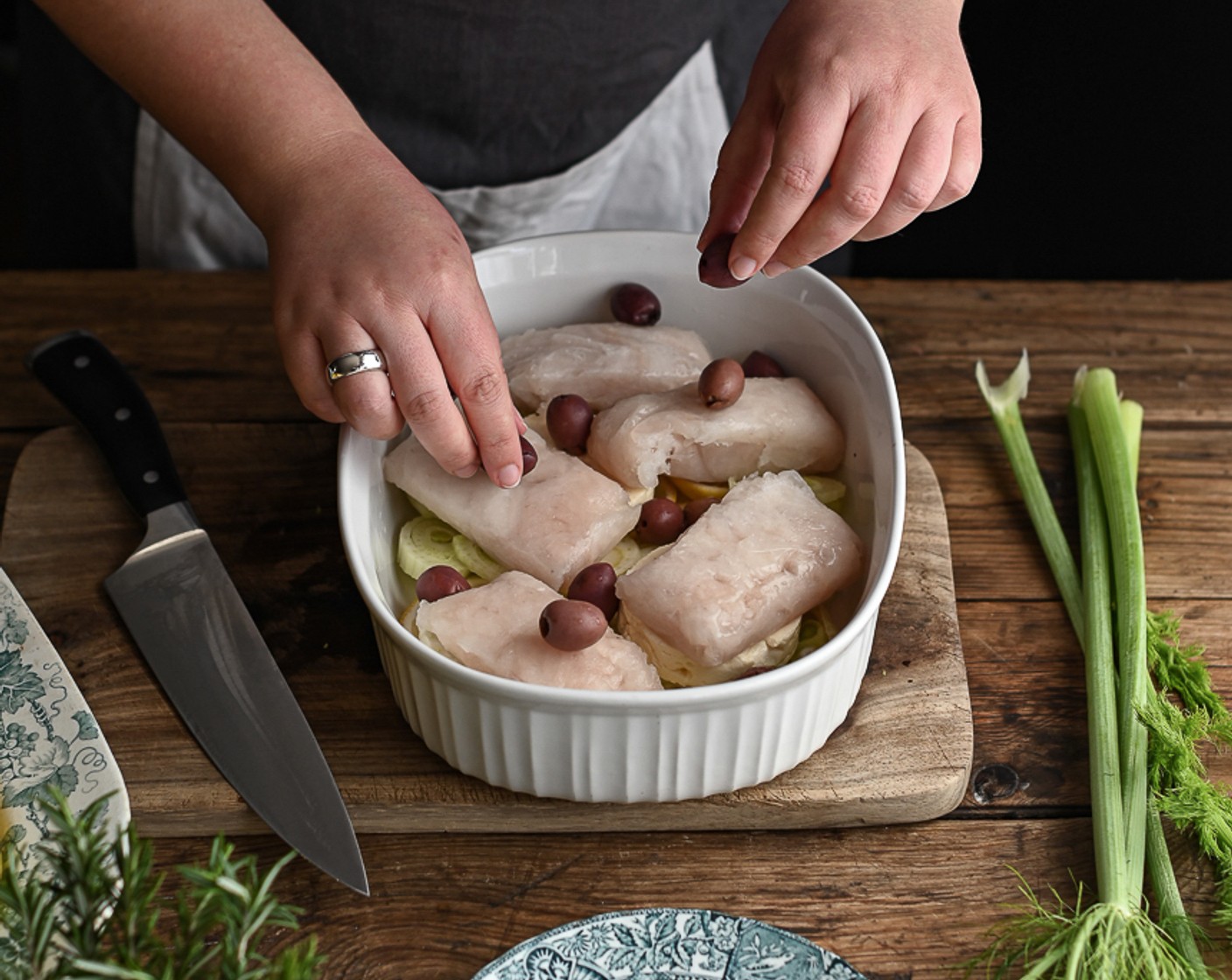 step 4 Add the Feta Cheese (as needed) and arrange the hake on top, scattering over the Black Olives (8).