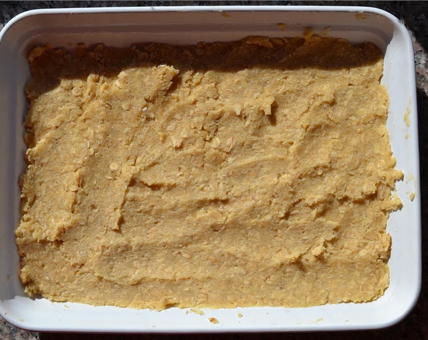 step 6 Split the dough in half. Press one half into the baking dish so it forms an even layer.