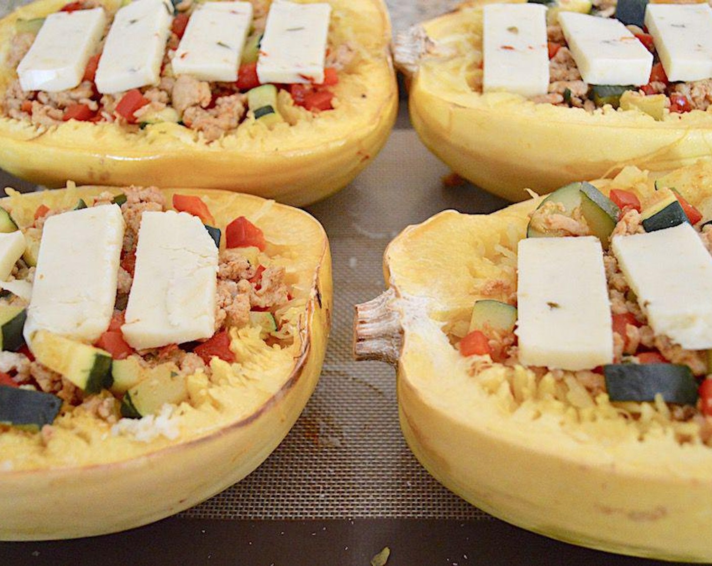 step 5 Then evenly divide the chicken filling among the four squash halves to really stuff them to the brim. Then top each squash half with 4 slices of the Pepper Jack Cheese (1 block) to pretty much cover it. Then put the tray back in the oven for 10 minutes to meld everything together and melt the cheese.