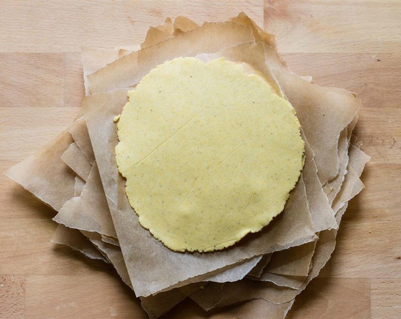 step 10 Carefully peel the dough off the parchment and place on a smaller piece of parchment. Continue this process and keep stacking the tortillas with small sheets of parchment so they don't stick together. Keep the stack covered with a towel as you work.
