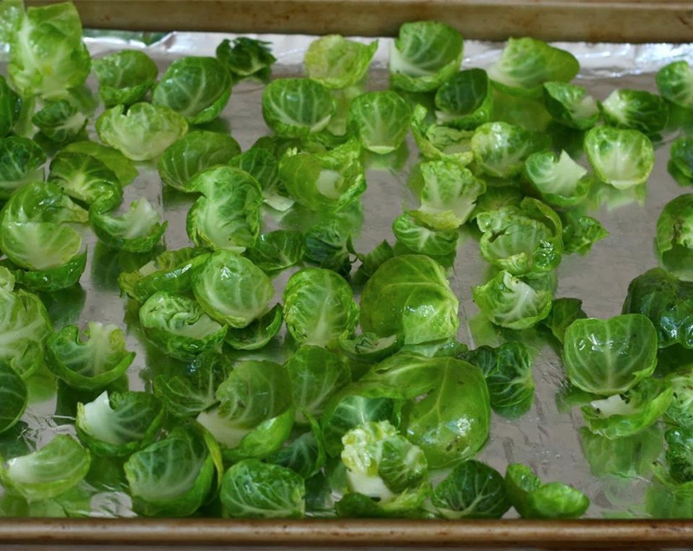 step 3 Wash leaves and thoroughly dry in salad spinner. Toss with Olive Oil (1/2 Tbsp) and spread in an even layer on the baking sheet.