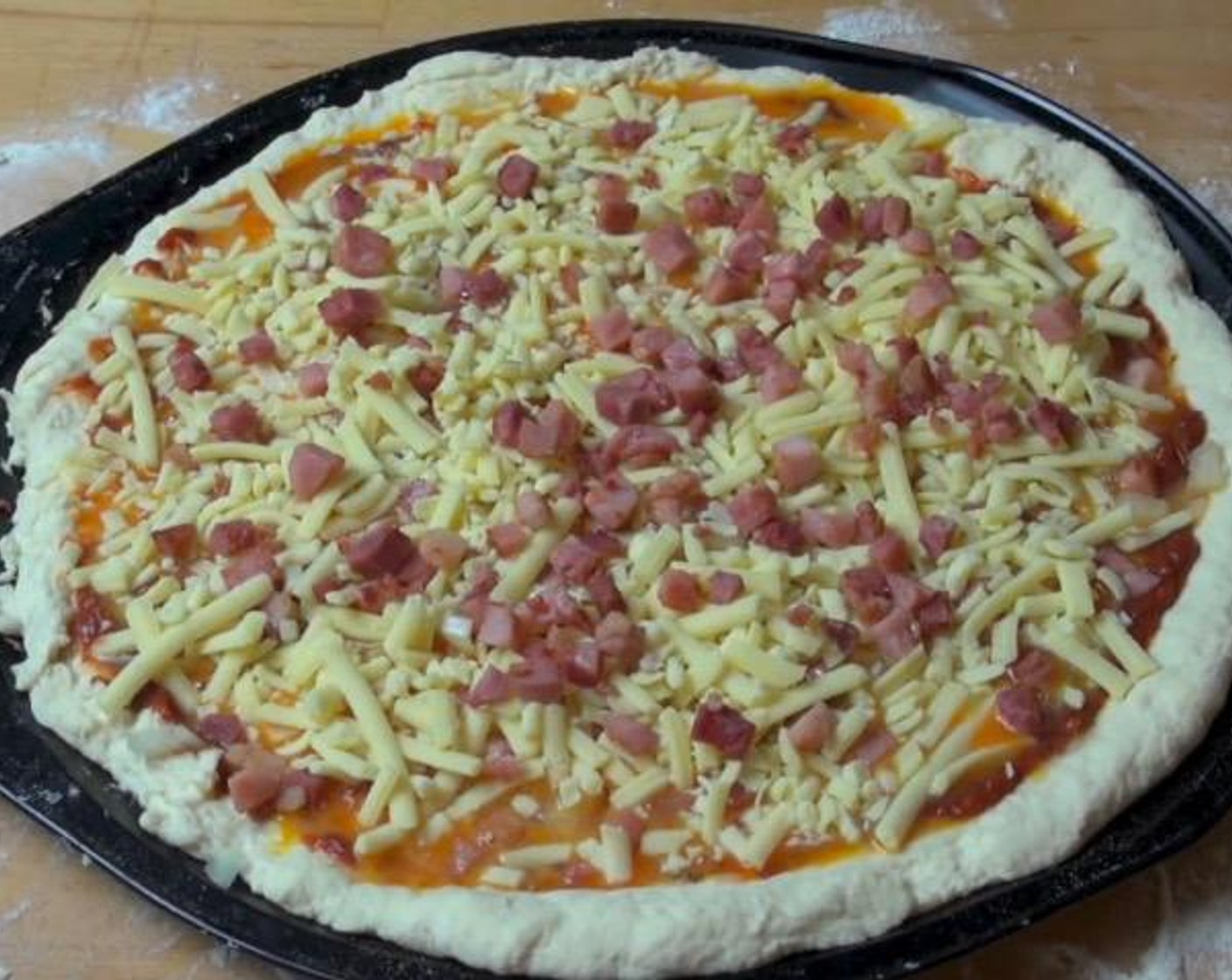 step 3 Top dough with Pizza Sauce (to taste), half of the lightly fried Bacon (7 oz) and Yellow Onion (1/2). Pour the Eggs (5) over top. Sprinkle Cheese (2 cups) on top, then finish with the remaining bacon.