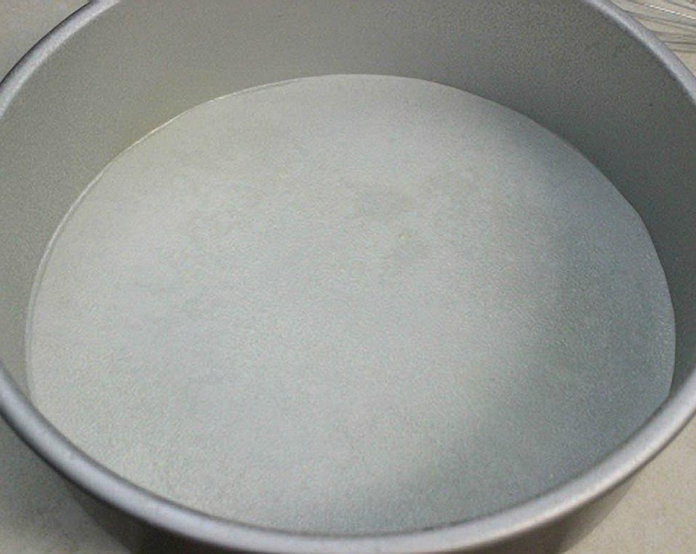 step 2 For the cake: Spray a 10 inch round cake pan with baking spray, or brush it with melted butter and then sprinkle with flour. Line the bottom of the pan with parchment paper and spray it with baking spray too.