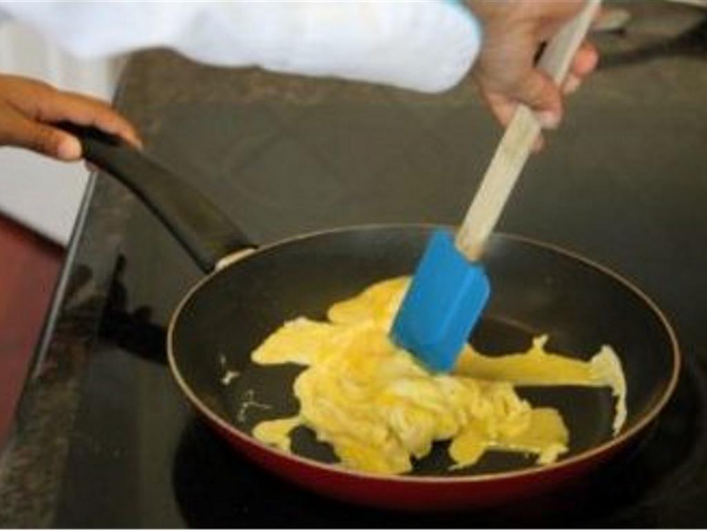 Step 5 of Sausage and Egg Breakfast Stacks Recipe: Spray a skillet with Olive Oil Cooking Spray (as needed). Pour the egg mixture in the heated pan. As the edges and bottom of the eggs get firm, push the edges towards the middle Continue to push and flip the firm parts of the eggs until no liquid parts remain. Place cooked eggs in a bowl.