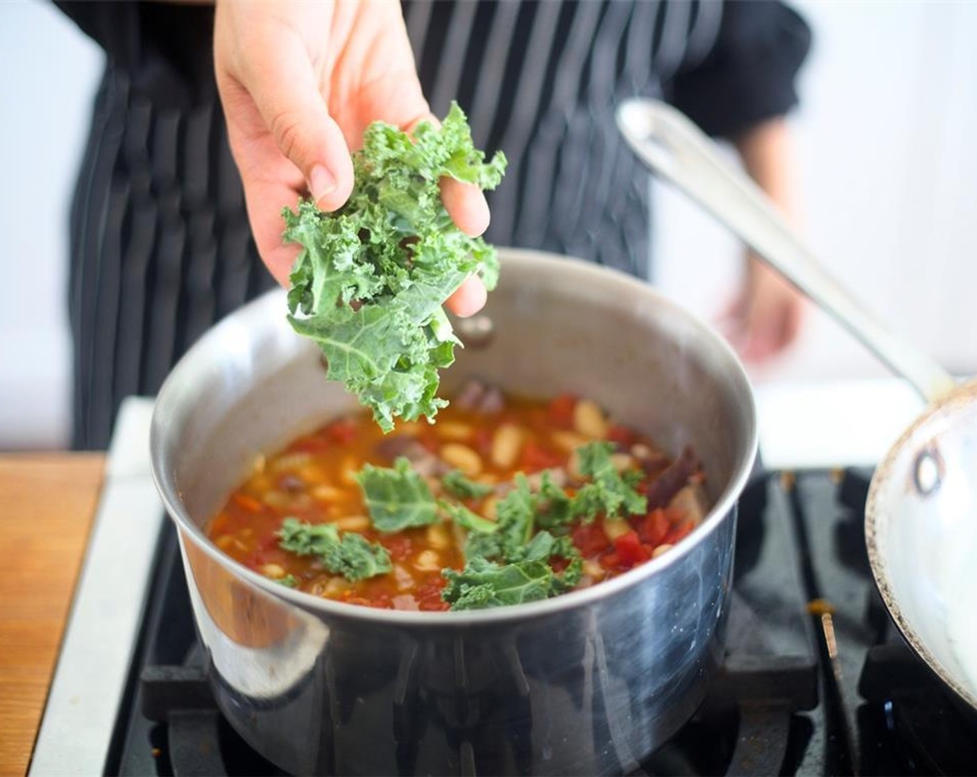 step 16 Drain Tomatoes (1 1/2 cups) and discard liquid. Stir Kale (3 1/3 cups) and diced tomatoes into stew, bringing to a boil, then reduce heat to simmer and cook for 5 minutes.