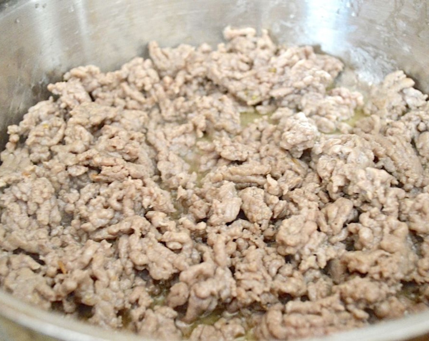 step 1 Get a large pot of water on to boil for the pasta. Then get out a large, deep skillet and heat the Olive Oil (1 dash) in it over medium-high heat. Brown the Ground Sweet Italian Sausage (1 lb) in it until cooked through completely. Transfer it to a plate.