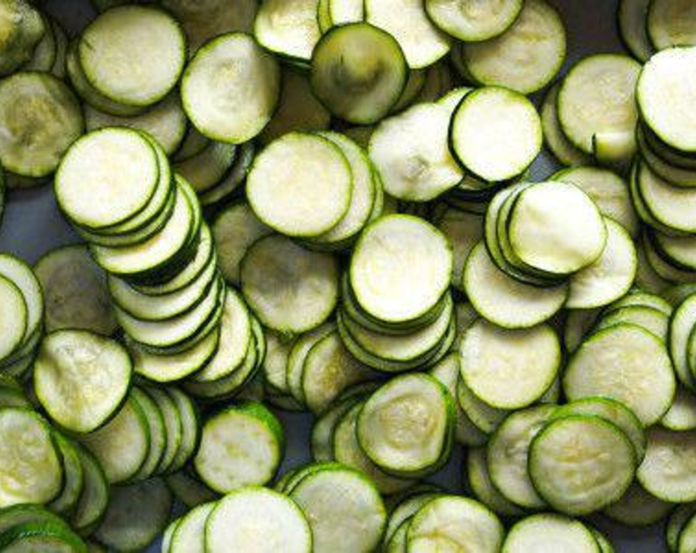 step 5 Spread the zucchini on a clean dish towel, roll it up, and gently squeeze it to rid of the excess moisture. Add to a bowl and toss with a drizzle of Olive Oil (as needed).