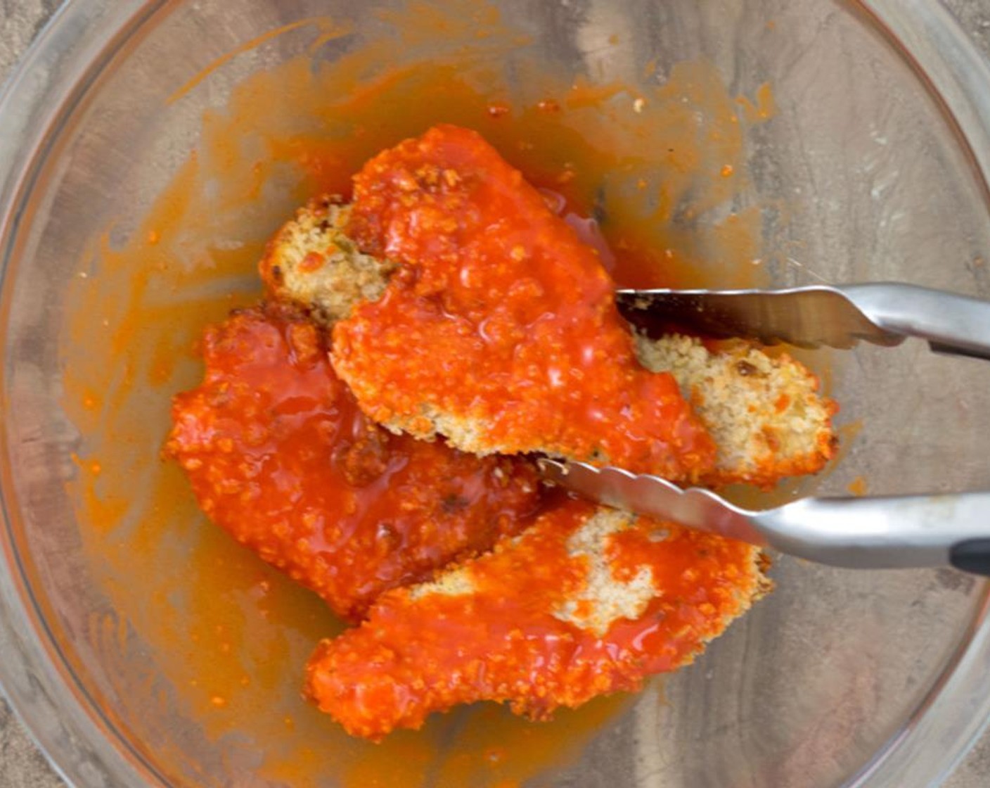 step 8 In a medium bowl add Buffalo Sauce (1/2 cup) and chicken tenders, and toss with a pair of tongs until fully coated.