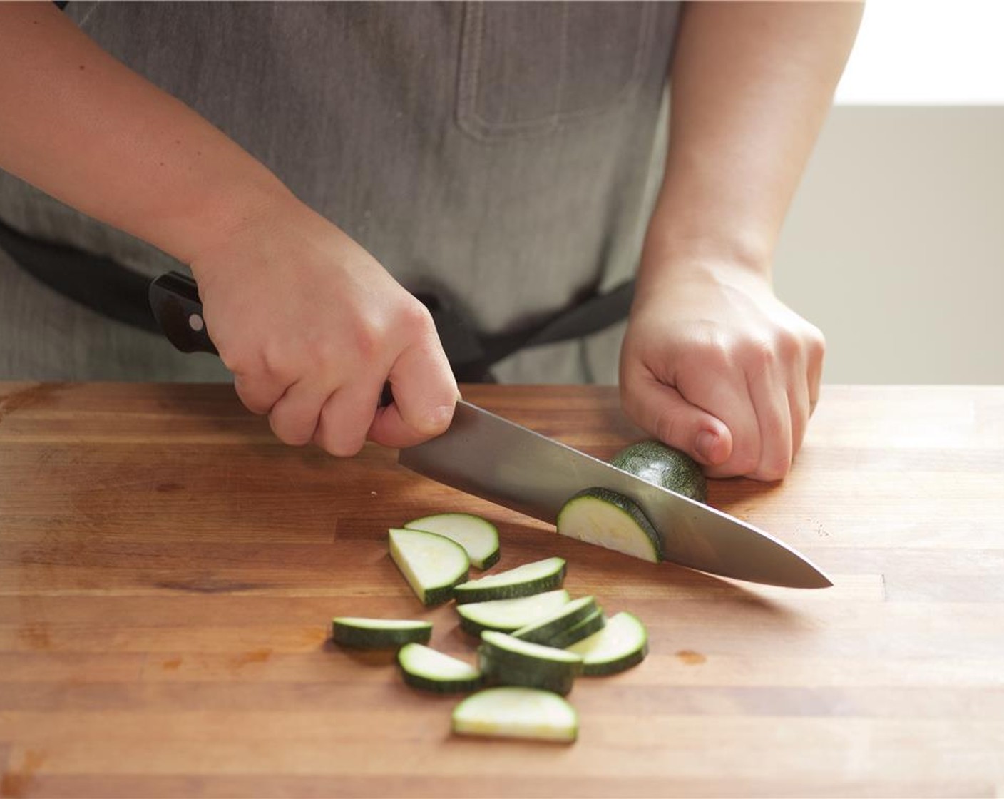 step 1 Slice the Zucchini (1) in half lengthwise, then slice into half inch thick half moon slices. Set aside.