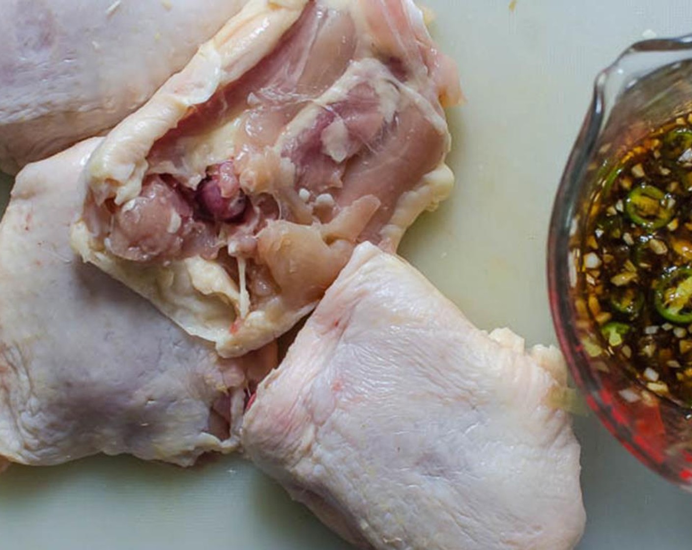 step 4 Place the trimmed meaty Chicken Thighs (4) in a zip-top plastic bag and pour the marinade over them. Squeeze the air out of the bag and seal it tightly. With your hands work the chicken thighs into the marinade until well coated.