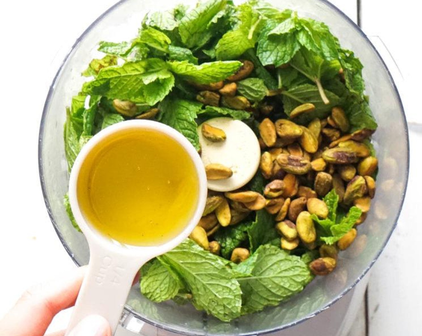 step 1 Combine the Fresh Mint Leaves (1 cup), Unsalted Pistachios (1/4 cup), and Garlic (1 clove) in a food processor. Process until ground, then pour the Olive Oil (1/4 cup) in a steady stream until desired consistency achieved.