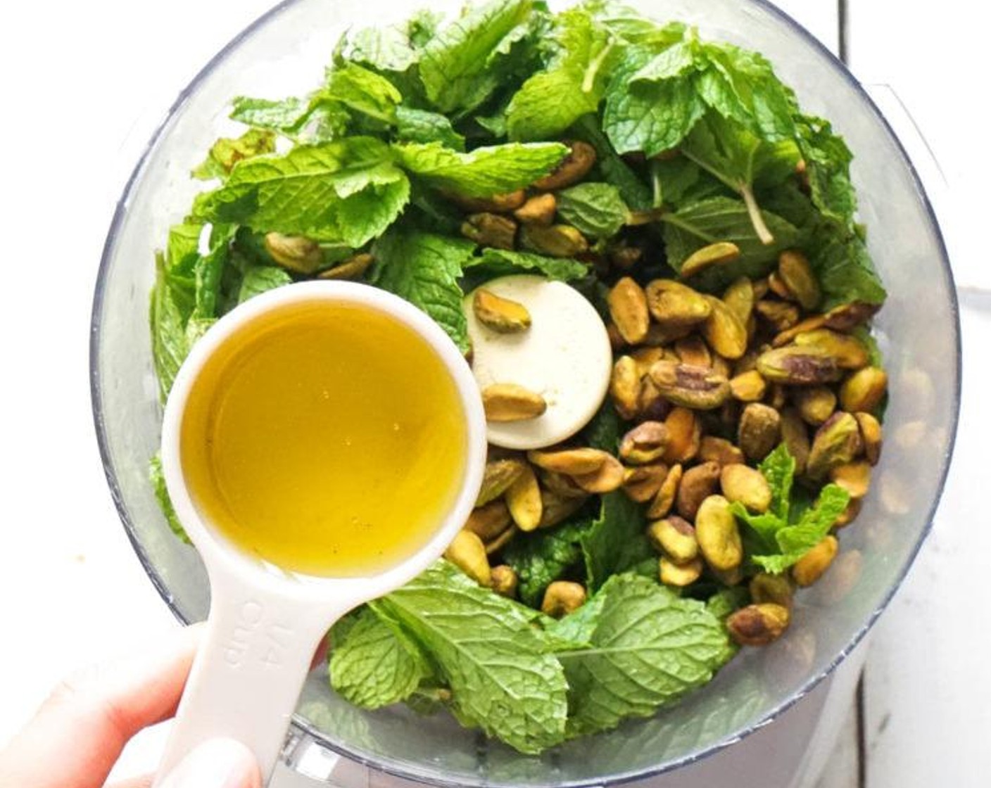 step 1 Combine the Fresh Mint Leaves (1 cup), Unsalted Pistachios (4 Tbsp), and Garlic (1 clove) in a food processor. Process until ground, then pour the Olive Oil (4 Tbsp) in a steady stream until desired consistency achieved.