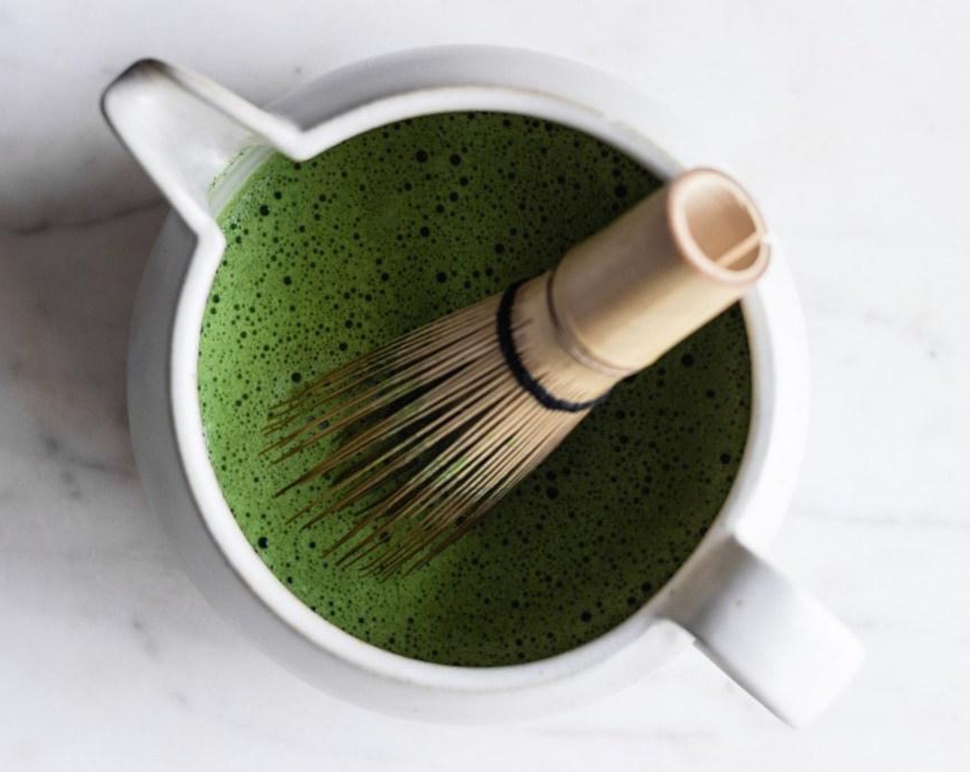 step 3 Pour Water (2 fl oz) over the matcha, and use a bamboo whisk in a zigzag motion to whisk the matcha until smooth and frothy, approximately 10-15 seconds.