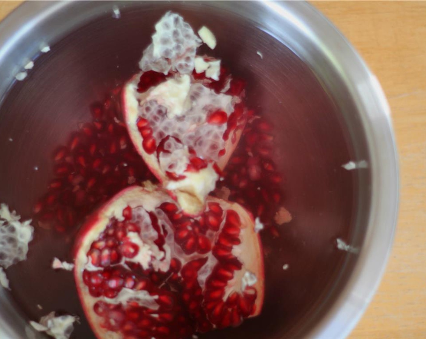 step 6 Soak the scored pomegranate in water for a few minutes, before breaking it apart and seeding it under water. The pith with float to the surface of the water as you continue to agitate the seeds. Drain them and side them aside.