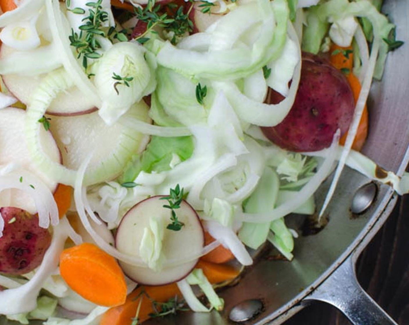 step 2 Transfer the sausages to a plate. Into the pan over medium heat, layer in half of the Onion (1), Red Potatoes (1 1/2 cups) and Green Cabbage (1/2 head). Layer the remaining onions, potatoes, and cabbage. Sprinkle with  Carrots (3) and Fresh Thyme (1 tsp).