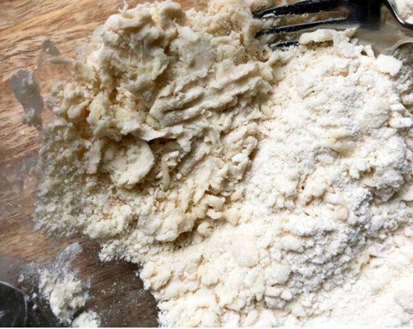 step 2 Moisten a little bit at a time by sprinkling a section with Water (1 Tbsp); gently toss with a fork. Push the moistened dough to the side of the bowl.